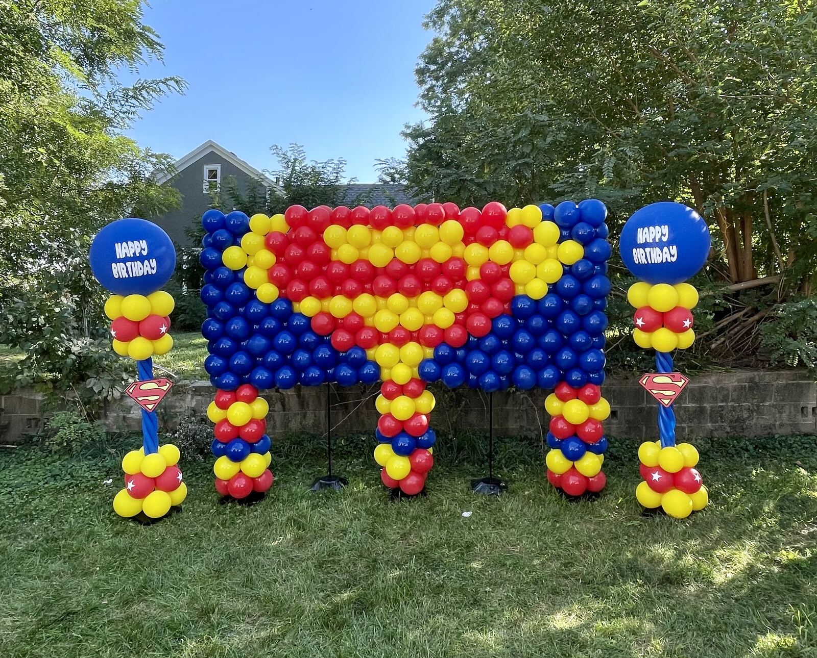 Blue red and yellow Superman-themed balloon backdrop wall