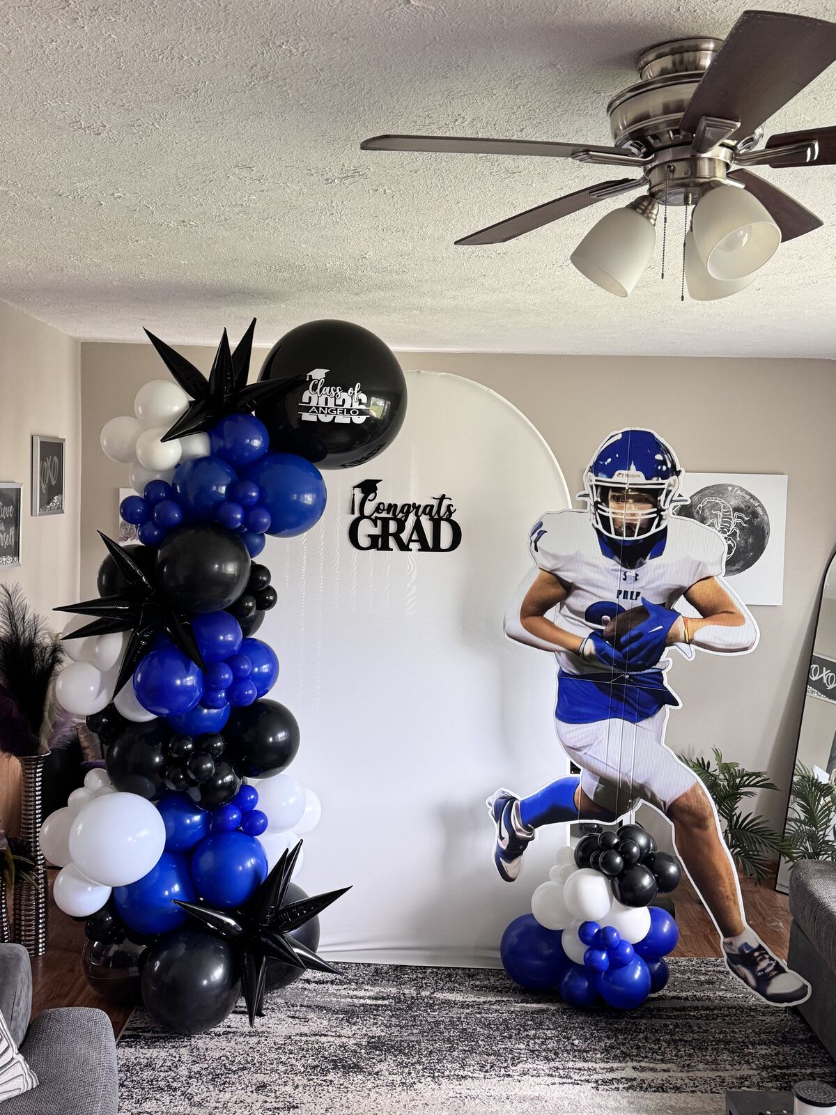 Balloon-topped step and repeat backdrop for a graduation photo op