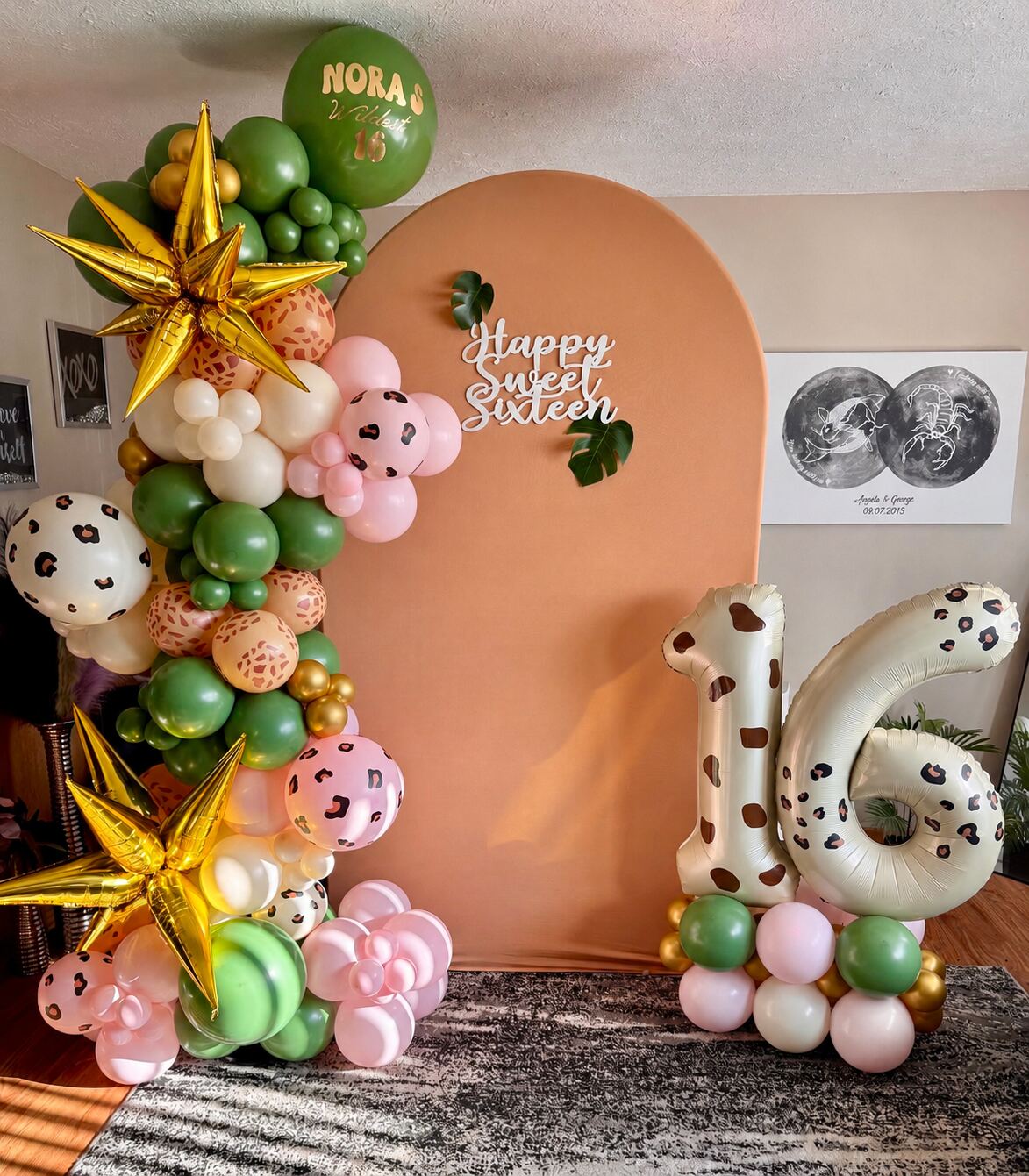 A green, cream, and pink leopard-print balloon backdrop for a sweet sixteen with 16 number balloons
