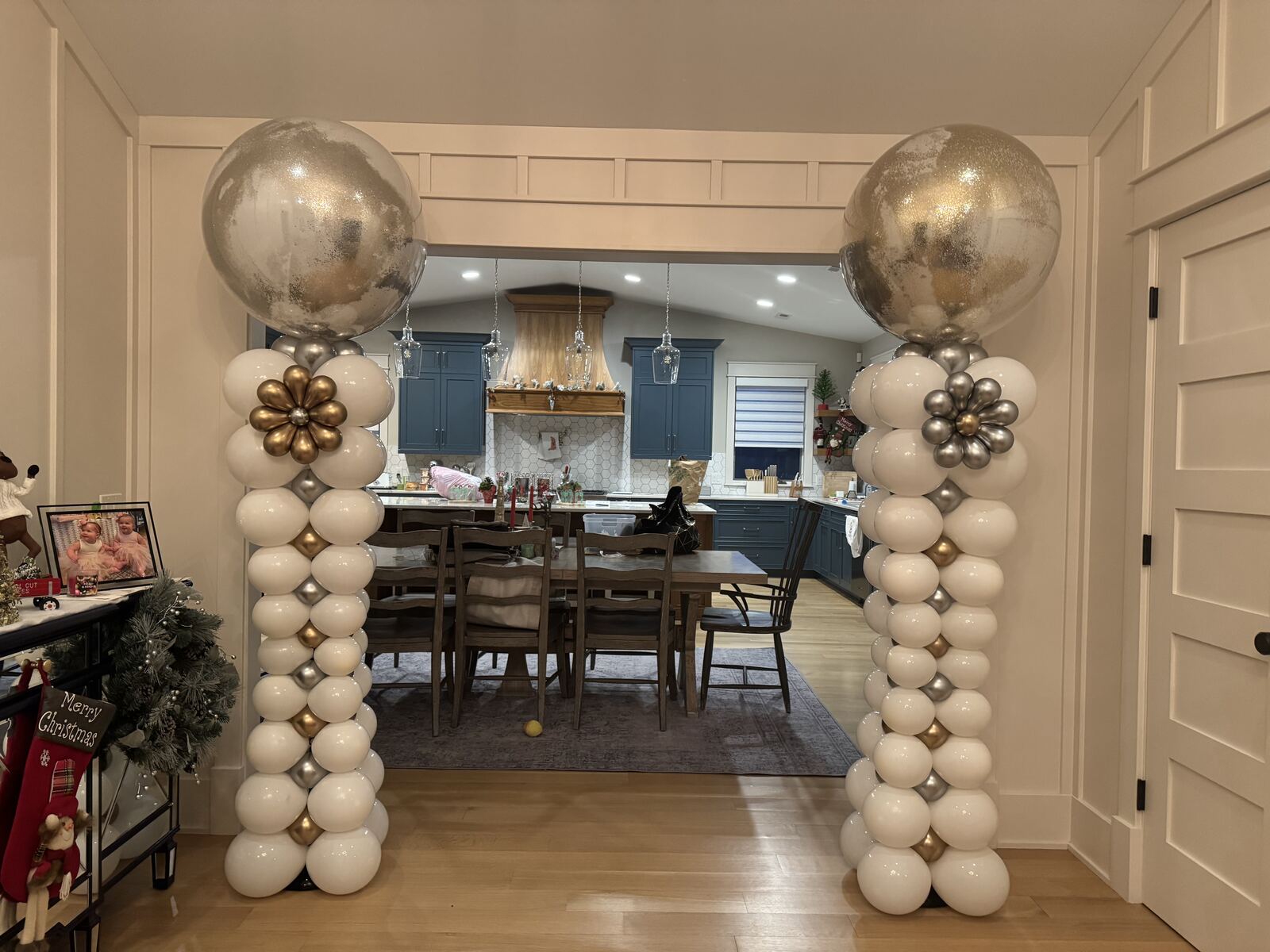 A pair of white, gold, and silver balloon columns framing a doorway
