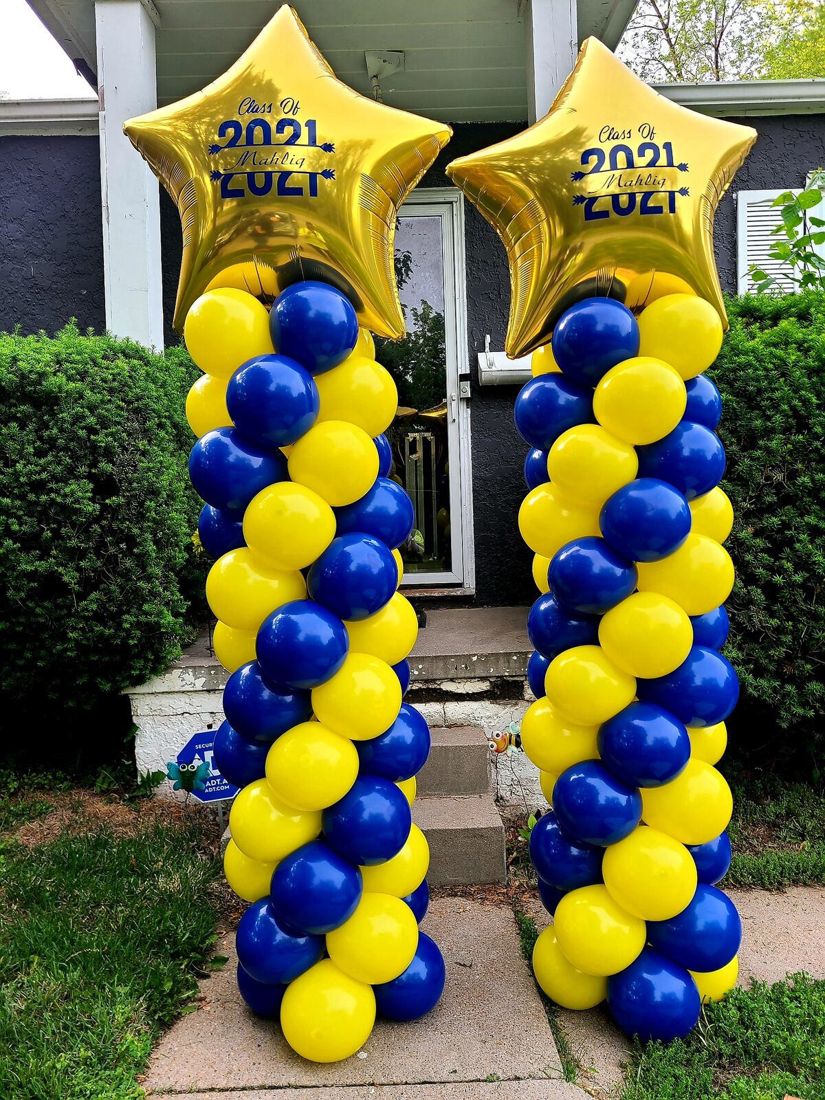 Blue and yellow graduation balloon columns with gold star toppers