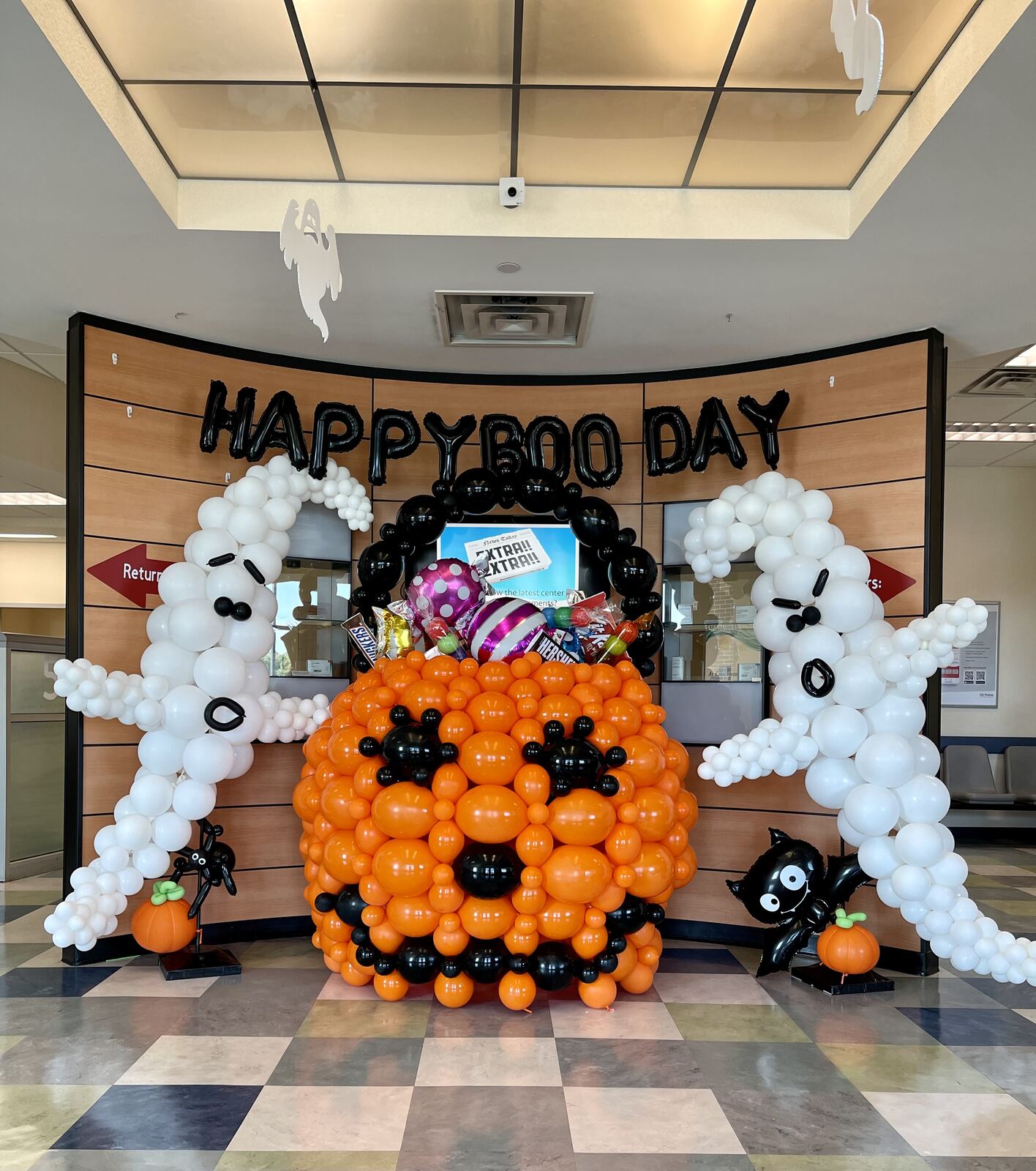White and black skeleton-themed Halloween balloon archway on a porch